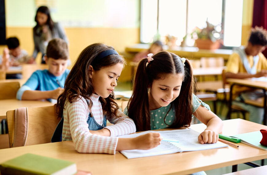 Écolières travaillant ensemble en classe